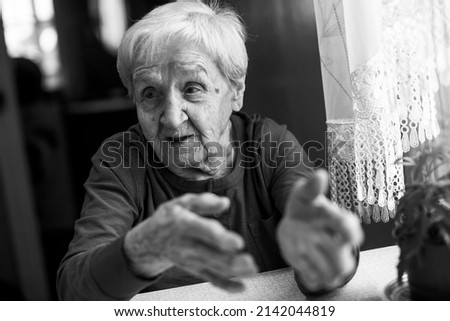 An old woman during a conversation. Black and white photo.