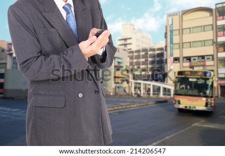 Double exposure of city and business man using smart phone 