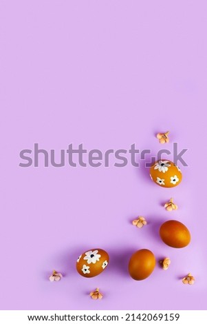 Easter card design. Easter eggs decorated flowers on lilac background. Flat lay, top view, copy space.Border.