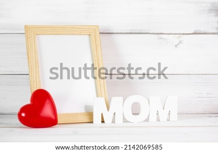 Red Heart with Photo Frame over white wood background. Symbol of love mom concept.