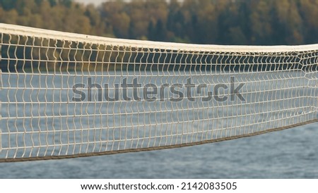 Photography of the beach volleyball net. Touristic resort in front of lake in sunny summer day time. Holidays concept. Beautiful landscape. Close up photography. Concept of sport activity