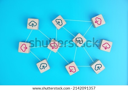 Cloud upload and download icons on connected wooden cubes. The idea of sharing or transferring data online.                       