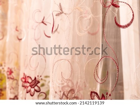 The curtain is made in warm pink tones with twisted colorful patterns.