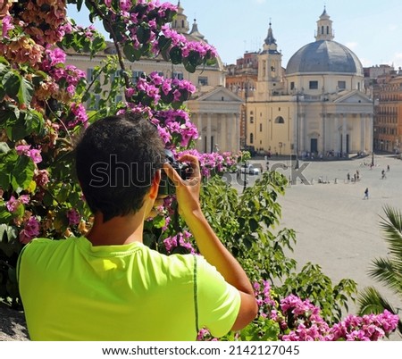 Young photographer in Rome in Italy and the Square of People called Piazza del Popolo in Italian Language and the flowers