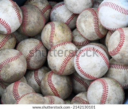 abstract close up of a bucket of old used dirty baseballs