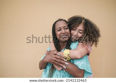 Happy african mother and adult daughter hugging together outdoor - Family love Royalty-Free Stock Photo #2142132463