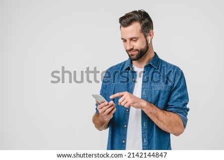 Happy active young student male man freelancer listening to the music in earphones, choosing sound track, podcast radio station playlist in music application Royalty-Free Stock Photo #2142144847