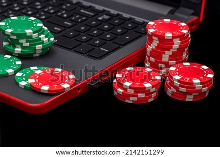 Gambling online casino Internet betting concept. Jackpot, casino chips. computer keyboard, laptop with poker chips, dice. Casino tokens, gaming chips, checks, or cheques. Royalty-Free Stock Photo #2142151299
