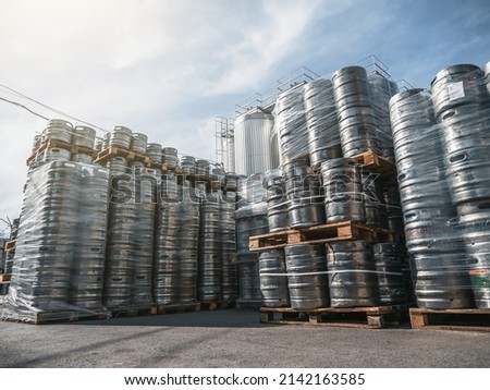 Beer kegs. Many metal barrels or containers for brewery in pallets stacked outdoors Royalty-Free Stock Photo #2142163585