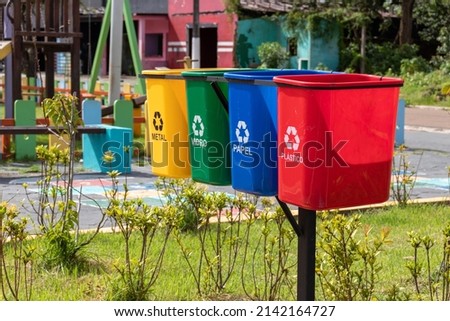 Set of bins for the selective collection of waste (metal, glass, paper, and plastic), in portuguese,  for recycling purposes. Royalty-Free Stock Photo #2142164727