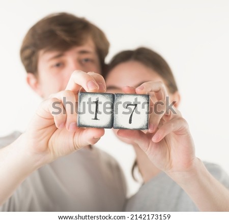 cubes with numbers in the hands of a young couple in defocus in the background