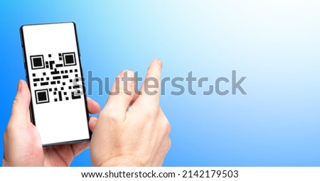 QR code scanning payment and verification. Hand using mobile smart phone scan QR code. Electronic gadget with QR code on screen. Blue background with free place. Modern technology concept