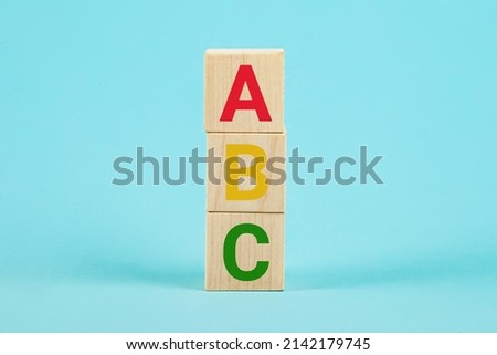 ABC on wooden blocks. ABC letters alphabet on wooden cube blocks in pillar form on blue background. Learn foreign languages. English for beginners. Copy the space