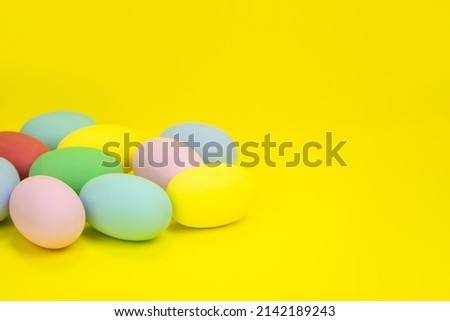 Easter eggs, multicolored on a yellow background with space for text. Concept banner, invitation, thank you card, layout . High quality photo