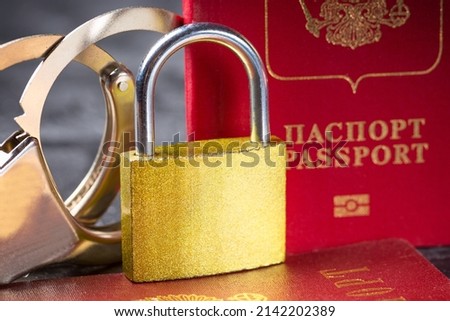 Russia Sanctions and Ukraine war concept. Russian Federation passports with handcuffs and padlock.
