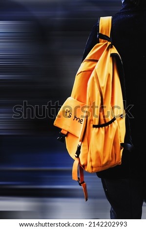 Yellow backpack with the inscription "I's me" in the subway