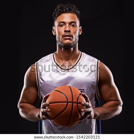 Who goes first. Studio shot of a basketball player against a black background.