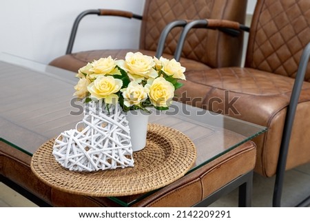 A bouquet of flowers on a table in an interior with leather armchairs.