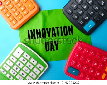 Selective focus.Calculator and colored notepaper with text INNOVATION DAY on a blue background.