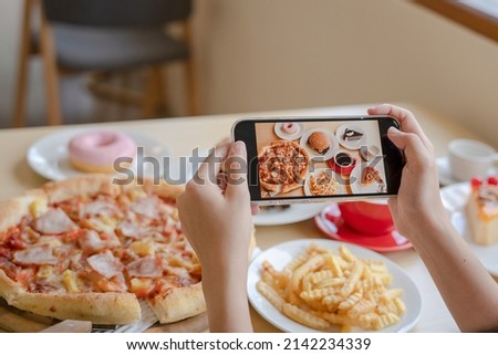 italian food. The restaurant owner takes a picture of the food on the table with a smartphone to post on a website. Online food delivery and ordering service
