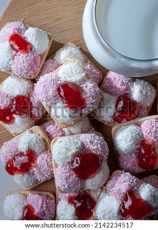 cookies with marshmallow, dried coconut flakes and strawberry jam, with a glass of ice cold milk on the side Royalty-Free Stock Photo #2142234517