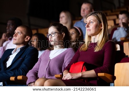 Portrait of family couple visiting theater with their teenage daughter, consumed with watching theatrical performance Royalty-Free Stock Photo #2142236061