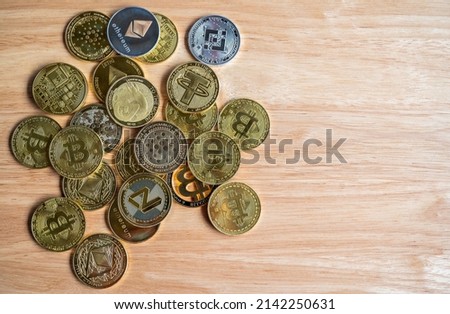 Top view of various kinds of cryptocurrency token coins on wooden table. Cryptocurrency is a digital or virtual currency that is secured by cryptography.
