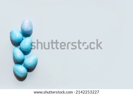 Blue lavender chocolate easter candy eggs on paper background.