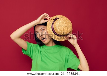 pretty brunette gestures with his hands with a hat in a green t-shirt studio model unaltered