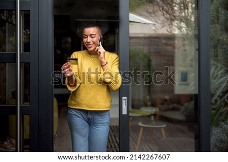 Smiling woman, checking her credit card number with the bank.