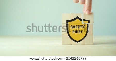 Safety first symbols, work safety, caution work hazards, danger surveillance, zero accident concept. Wooden cubes with smart grey background. Employees safety awareness at workplace. Safety banner. Royalty-Free Stock Photo #2142268999