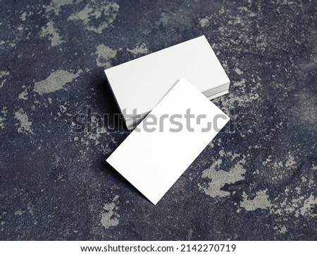 Blank white business cards on concrete background. Mockup for branding identity. Template for graphic designers portfolios.
