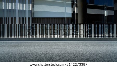 Side view of asphalt road with modern building exterior background Royalty-Free Stock Photo #2142273387