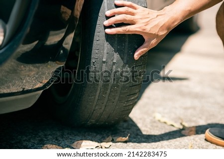 The man checking the front wheel tire. Car maintenance and service concept. Royalty-Free Stock Photo #2142283475