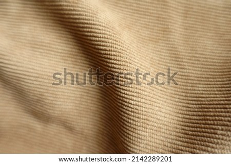 Close view of soft fold on light brown corduroy fabric