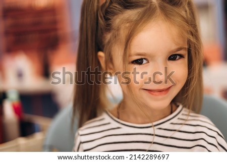 Portrait of a little beautiful girl with a stylish hairstyle in a beauty salon