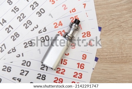 Paper calendar with vaping device on the table
