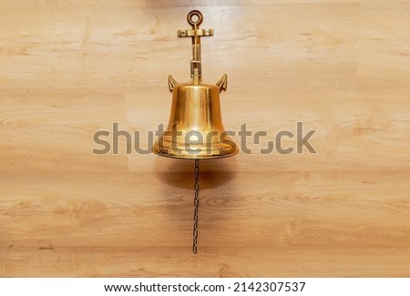A bell on the wall in the form of an anchor. The sea bell.
