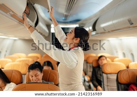 Cabin crew or air hostess working in airplane. Airline transportation and tourism concept. Royalty-Free Stock Photo #2142316989