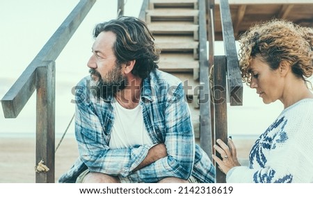 Relationship problems for adult couple. Man and woman sad and serious sitting outdoor. Matures in disagreement. Divorce thoughtful and people worried and sad in outdoor. End marriage Royalty-Free Stock Photo #2142318619