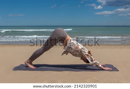 beautiful young blonde doing pilate, yoga on the beach