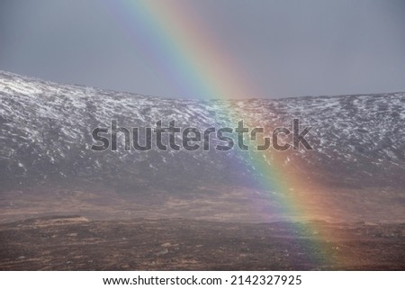Stunning landscape image of vibrant rainbow in front of mountains in Scottish Highlands Rannoch Moor Stob Dearg