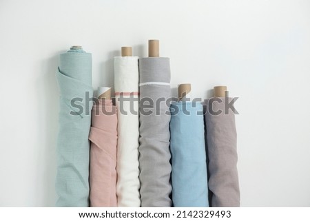 Different colors fabric linen rolls on the white walls, selective focus image
