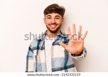 Young hispanic man isolated on white background smiling cheerful showing number five with fingers.