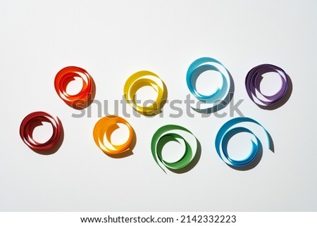 Rainbow colored paper circles on white background. Multicolor spirals pride