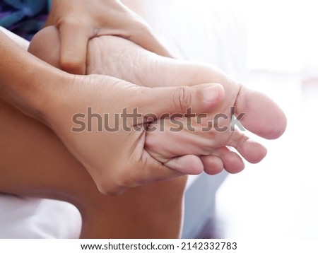 Asian women with health problems from chronic foot pain or Nerves are inflamed and numb on feet, Massage to relieve aches.