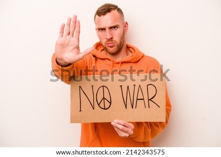 Young caucasian man holding no war placard isolated on white background