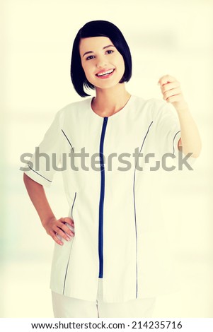Woman doctor or nurse holding blank business card in her hand