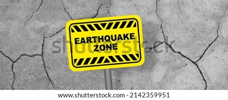 Yellow earthquake zone sign on wall background