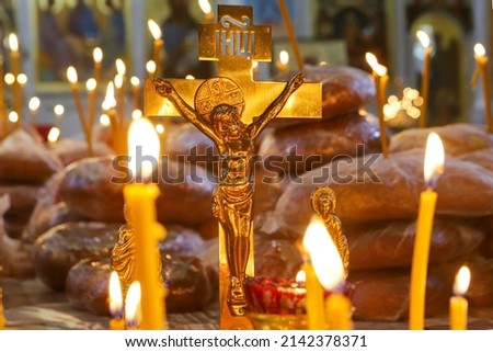 Funeral service, funeral liturgy in the Orthodox Church. Christians light candles in front of the Orthodox cross with the crucifix, the concept of Orthodox faith and religion. Royalty-Free Stock Photo #2142378371
